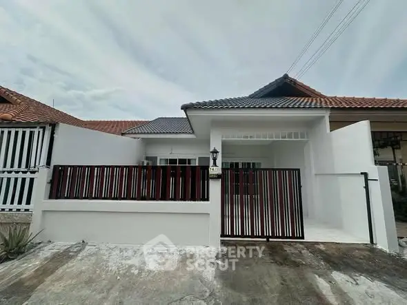 Charming single-story home with modern facade and gated entrance in a serene neighborhood.