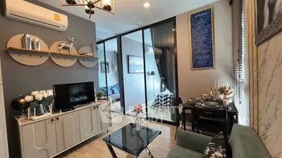 Modern living room with stylish decor and glass partition to bedroom