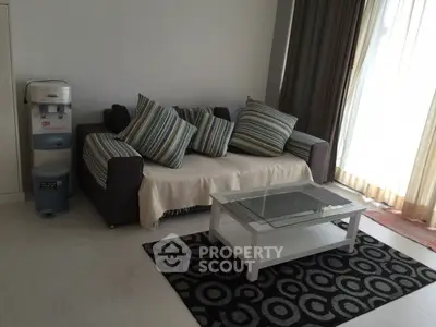 Cozy living room with stylish sofa and glass coffee table, perfect for relaxation.