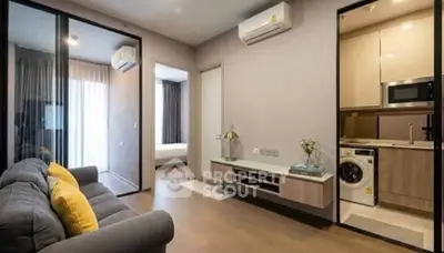Modern apartment interior with cozy living room and sleek kitchen featuring built-in appliances.