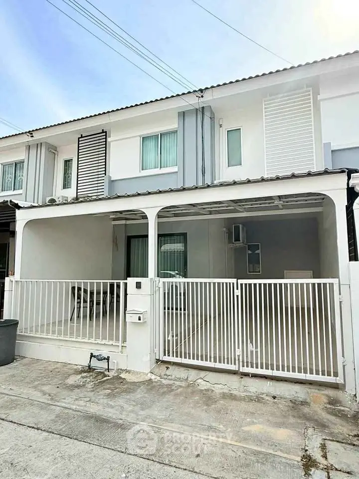 Modern townhouse exterior with gated entrance and clean facade