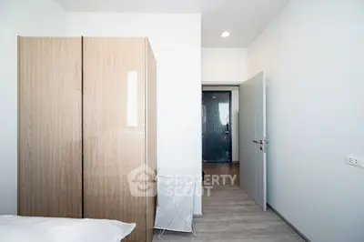 Modern minimalist bedroom with wooden wardrobe and white walls