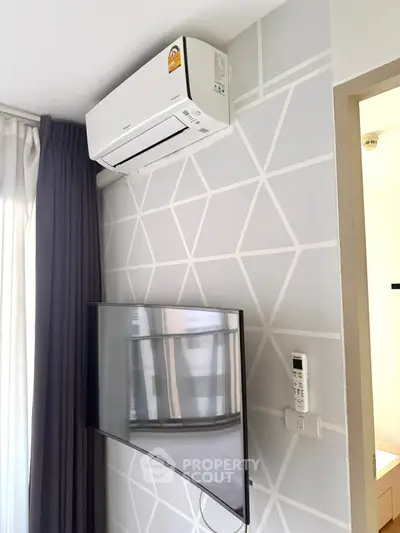 Modern living room with wall-mounted TV and air conditioning unit