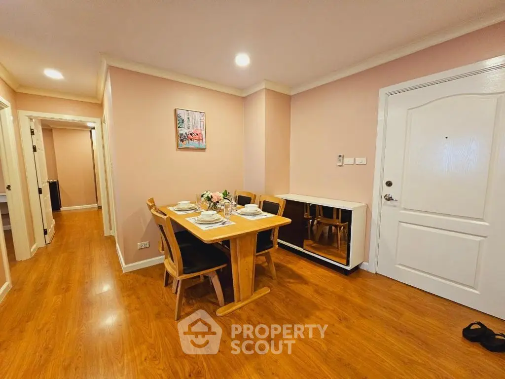 Charming dining area with wooden flooring and elegant decor in a cozy apartment.