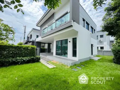 Modern two-story house with lush green lawn and sleek architectural design