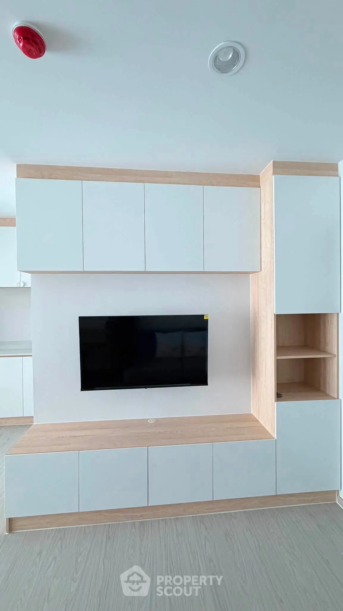 Modern living room with sleek built-in cabinetry and mounted TV, showcasing minimalist design.