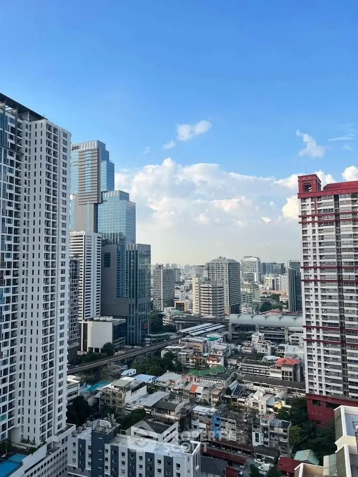 Stunning cityscape view from a high-rise balcony showcasing urban skyline and blue skies.