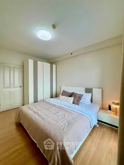 Spacious bedroom with modern decor and ample natural light, featuring a comfortable bed and stylish wardrobe.