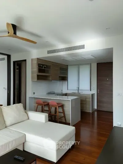 Modern open-layout living room with sleek kitchen and wooden flooring