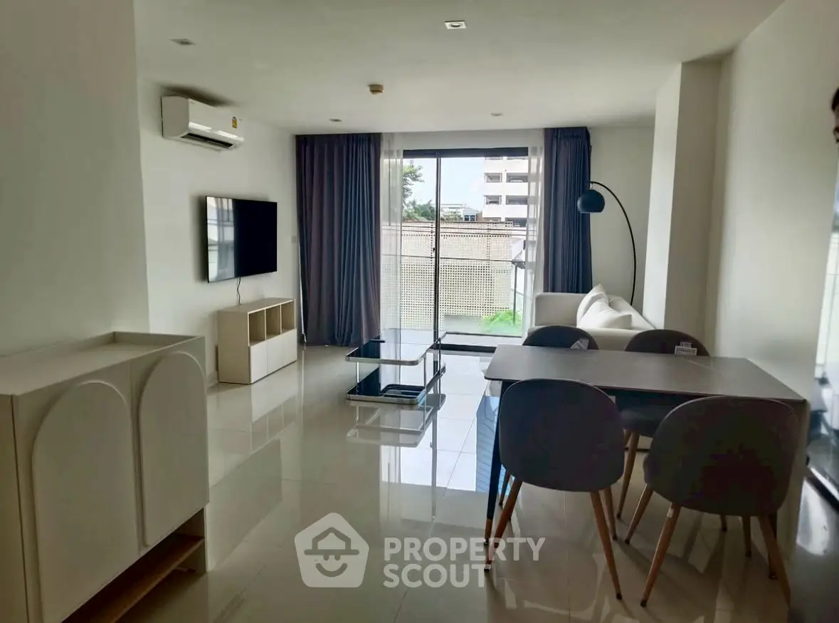 Spacious modern living room with sleek furniture and large windows offering natural light.