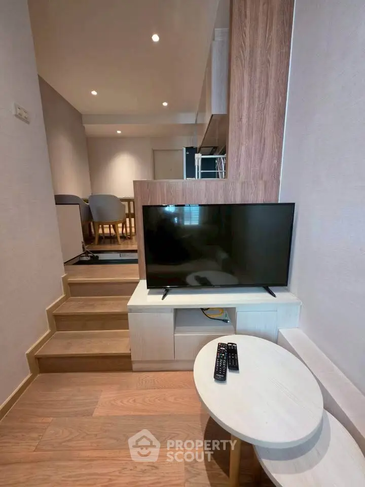 Modern living room with TV and stylish wooden accents in a cozy apartment