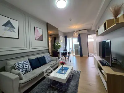 Modern living room with stylish decor and open layout, featuring a cozy sofa and elegant dining area.