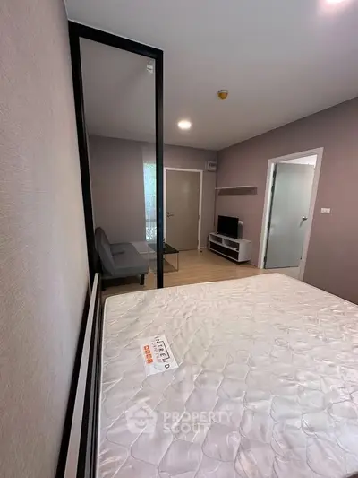 Modern bedroom with sleek design and glass partition, featuring a comfortable bed and stylish decor.