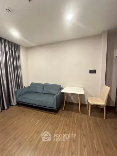 Cozy living room with modern sofa and dining table, perfect for relaxation and small gatherings.