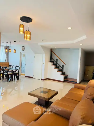Spacious living room with modern decor and elegant staircase in a luxurious home.