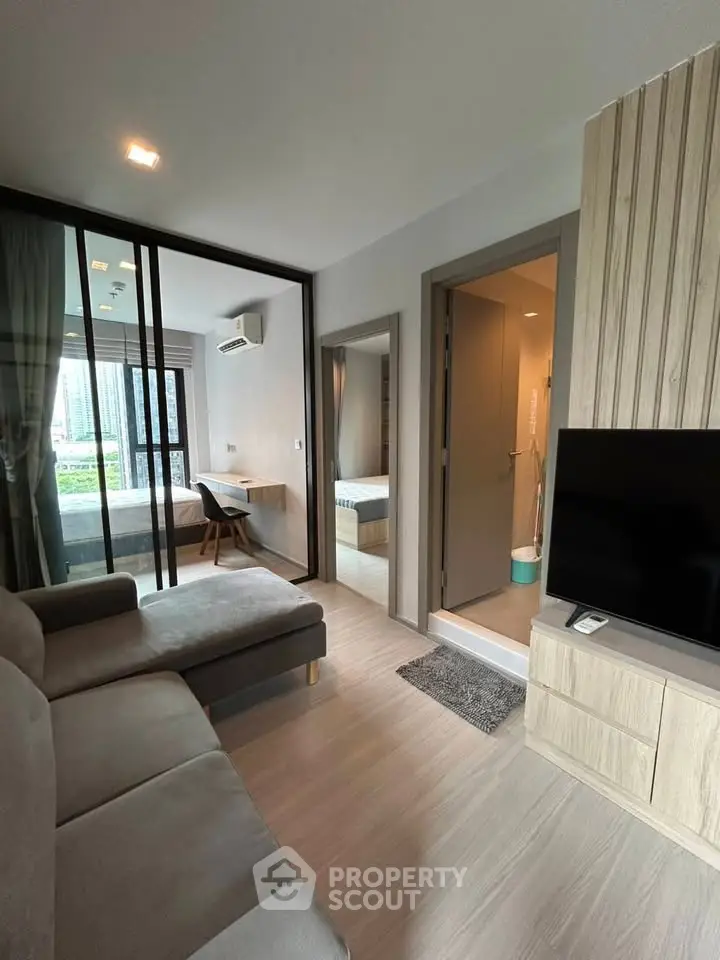 Modern living room with sleek furniture and large windows offering a city view, perfect for urban living.