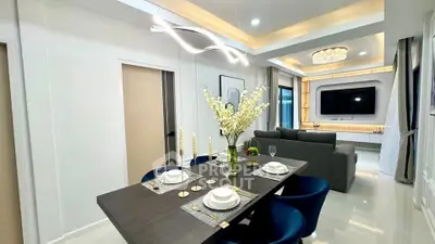 Modern living and dining area with elegant decor and contemporary lighting