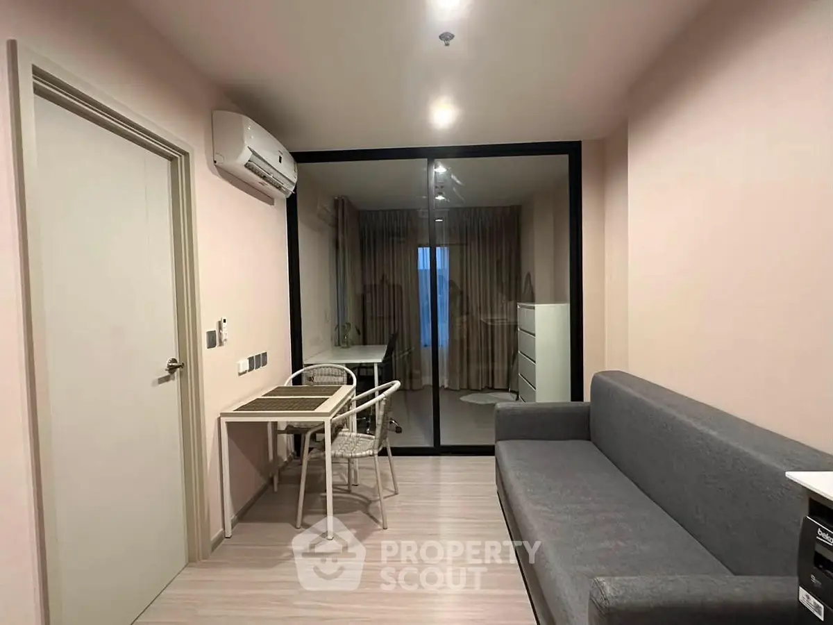 Modern living room with sleek furniture and glass partition in a stylish apartment.