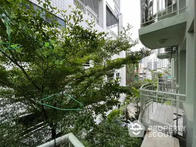 Charming urban balcony with lush greenery and city views, perfect for relaxation and enjoying nature.