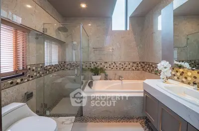 Luxurious bathroom with elegant marble finishes and spacious shower area.