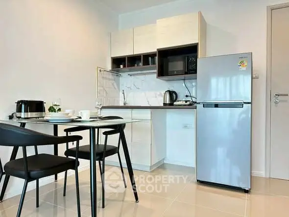 Modern kitchen with sleek appliances and dining area in a stylish apartment.