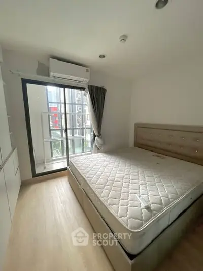 Modern bedroom with large window and air conditioning in a stylish apartment.