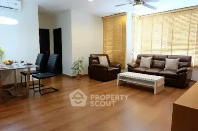 Spacious living room with wooden flooring and modern furniture in a bright apartment.