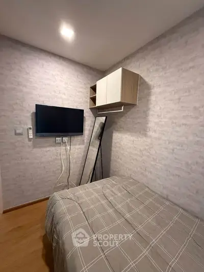 Cozy bedroom with modern decor, wall-mounted TV, and stylish storage solutions.