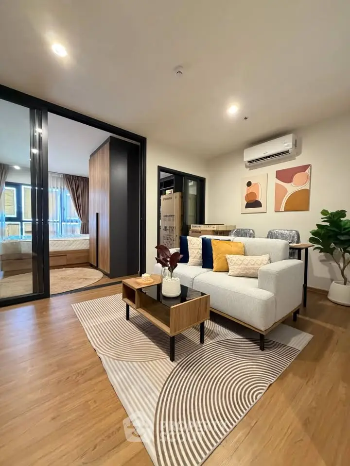 Modern living room with stylish decor and open layout, featuring a cozy sofa and elegant wooden flooring.