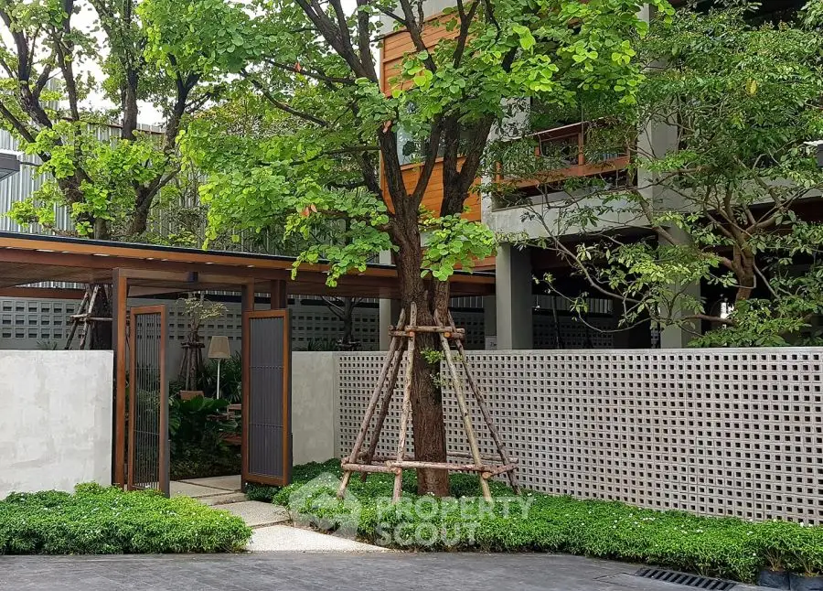 Charming garden entrance with lush greenery and modern design elements.