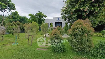 Charming garden entrance to a modern building surrounded by lush greenery.