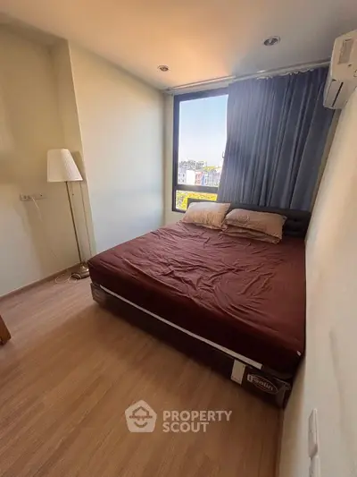 Cozy bedroom with large window and modern decor in urban apartment