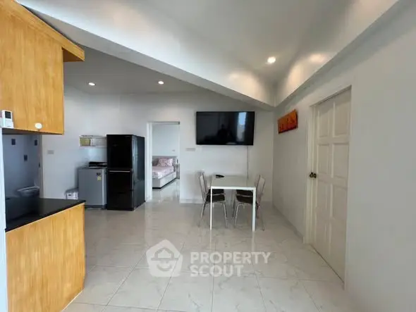 Modern open-plan kitchen and dining area with sleek design and bright lighting.