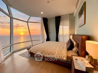 Luxurious bedroom with stunning ocean view and modern decor at sunset