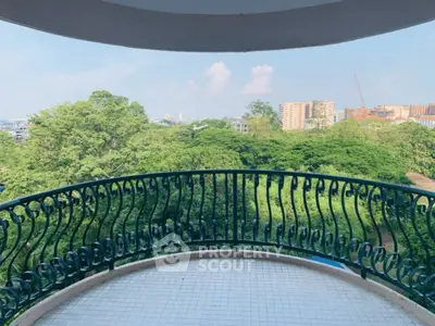 Spacious balcony with stunning green view in urban setting, perfect for relaxation and enjoying nature.
