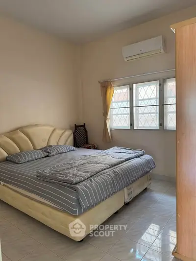 Cozy bedroom with double bed, air conditioning, and natural light from window.