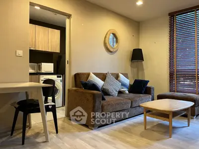 Modern living room with cozy sofa and open view to laundry area, featuring stylish decor and natural light.