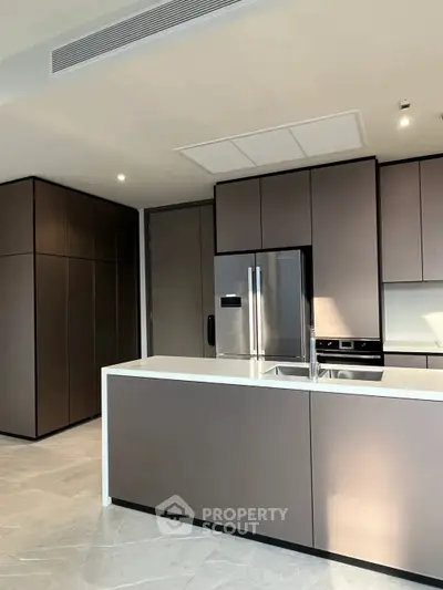 Modern kitchen with sleek cabinetry and stainless steel appliances in a luxury apartment.