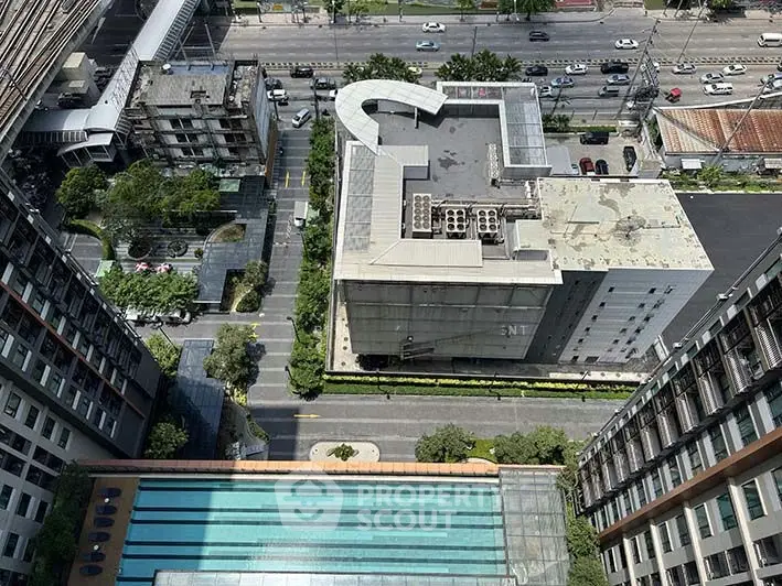 Stunning aerial view of urban residential complex with pool and cityscape.
