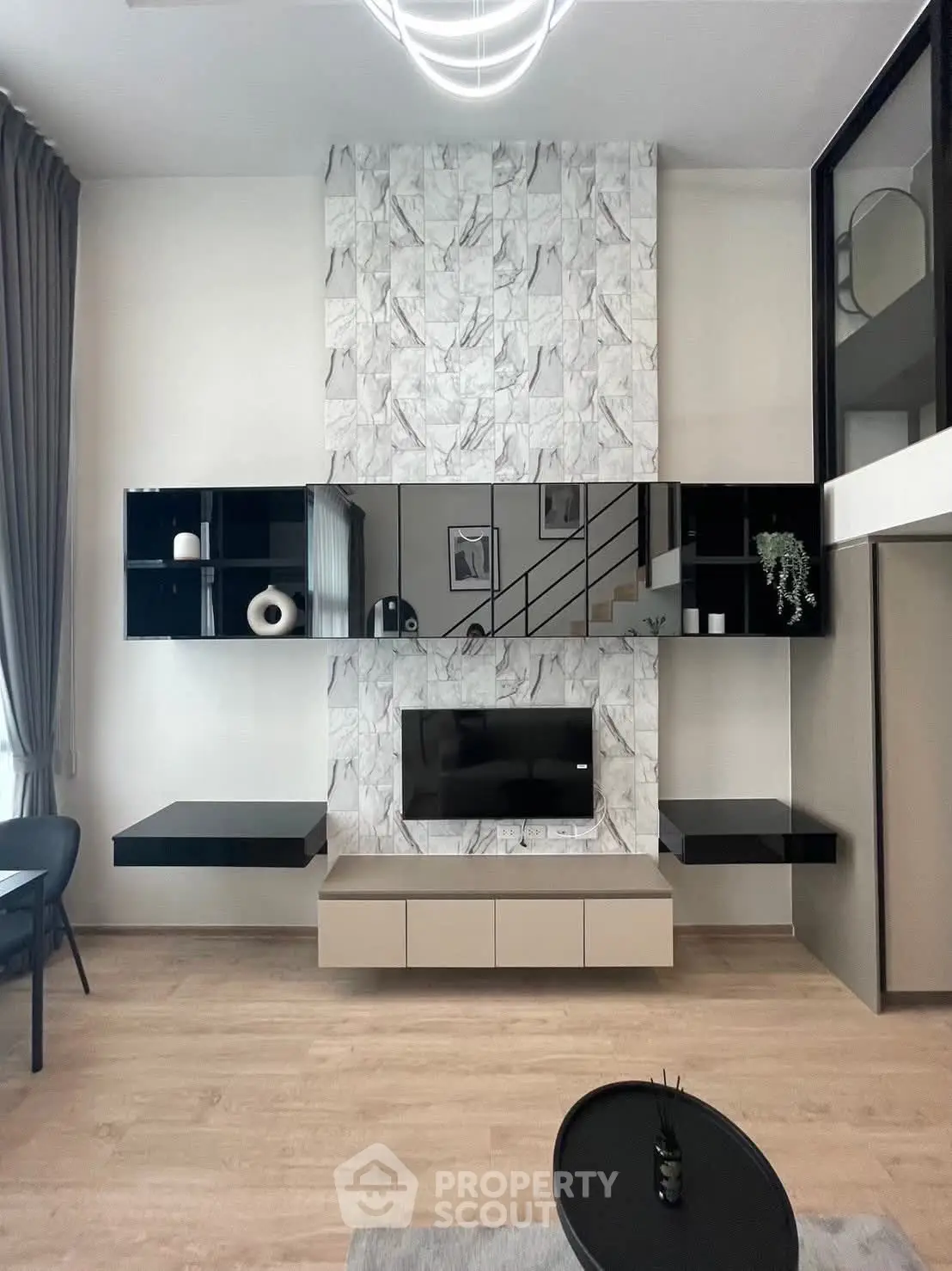 Modern living room with stylish marble feature wall and sleek black shelving.