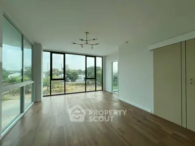 Spacious modern living room with large windows and elegant chandelier