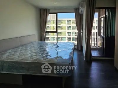 Spacious bedroom with large window and balcony view in modern apartment