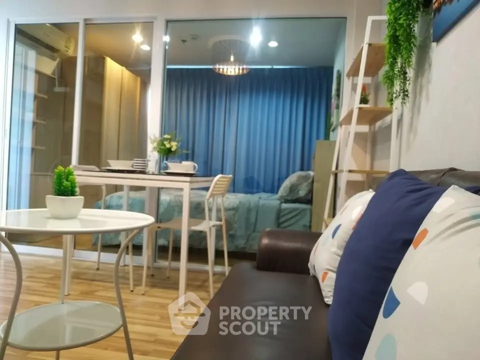 Modern living room with stylish decor and view into cozy bedroom