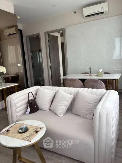 Modern living room with elegant sofa and dining area in open layout apartment.