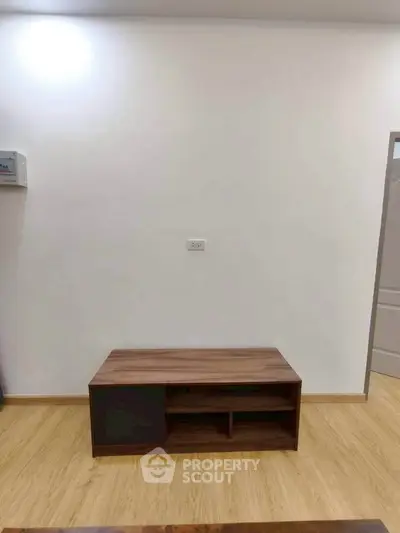 Minimalist interior with wooden floor and simple furniture, ideal for modern living spaces.