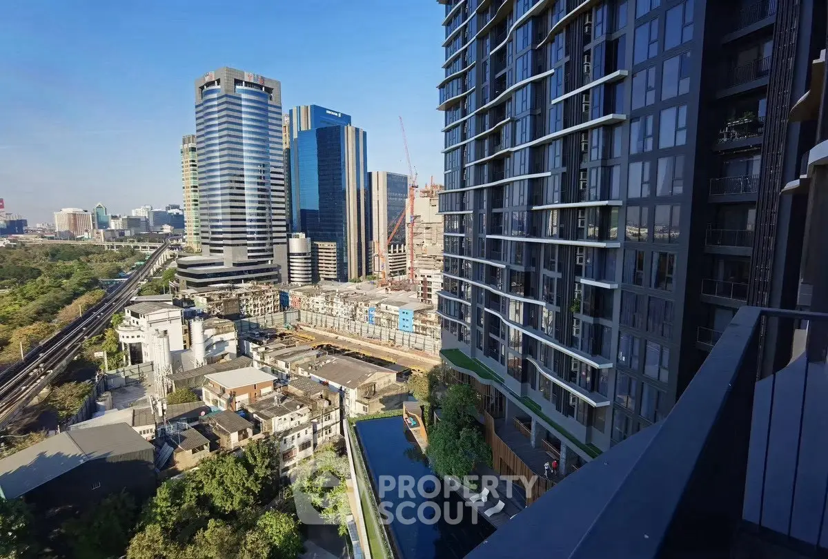 Stunning urban view from high-rise balcony overlooking city skyline and modern architecture.