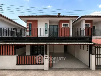 Modern two-story house with balcony and carport in a suburban neighborhood.