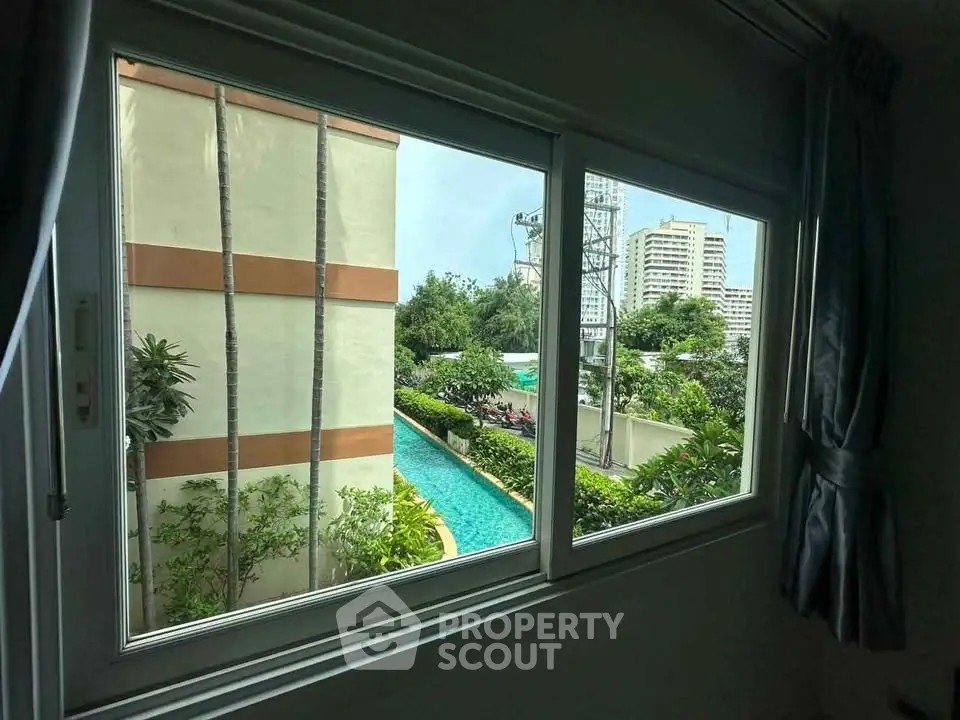 Stunning view of lush garden and pool from a modern window