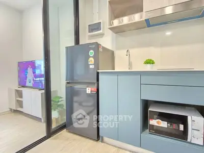 Modern kitchen with sleek appliances and stylish cabinetry in a contemporary apartment.