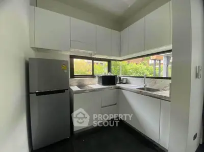 Modern kitchen with sleek white cabinets and stainless steel appliances